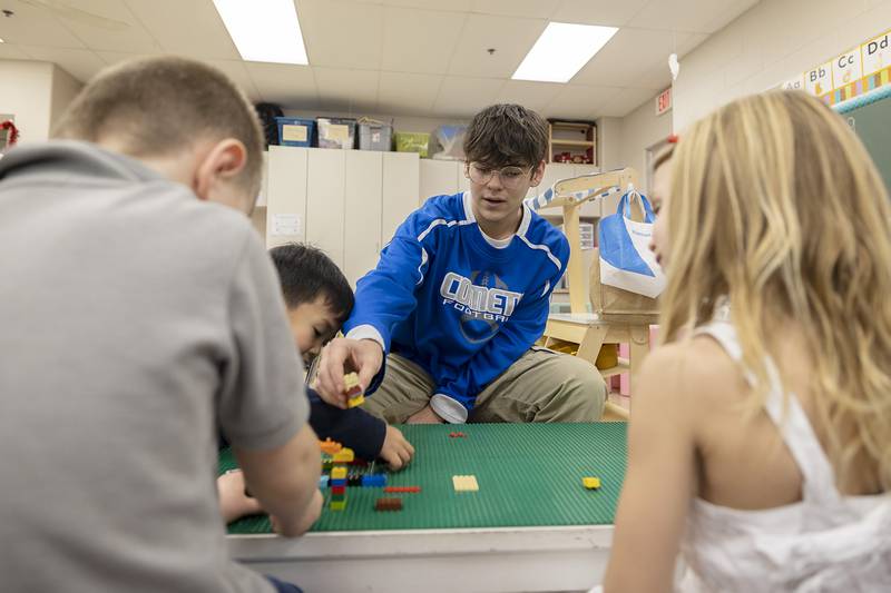 Newman Central Catholic High School junior Espen Hammes plays with Lego bricks alongside St. Mary’s School students in Sterling on Thursday, Feb. 2, 2023.
