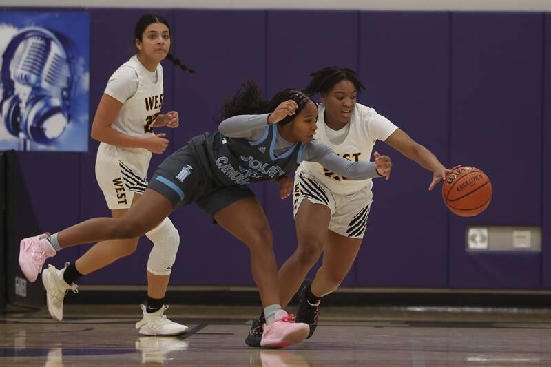 Joliet West’s Mariah Shelton steals the ball from Joliet Catholic’s Symone Holman in the WJOL Basketball Tournament at Joliet Junior College Event Center on Monday