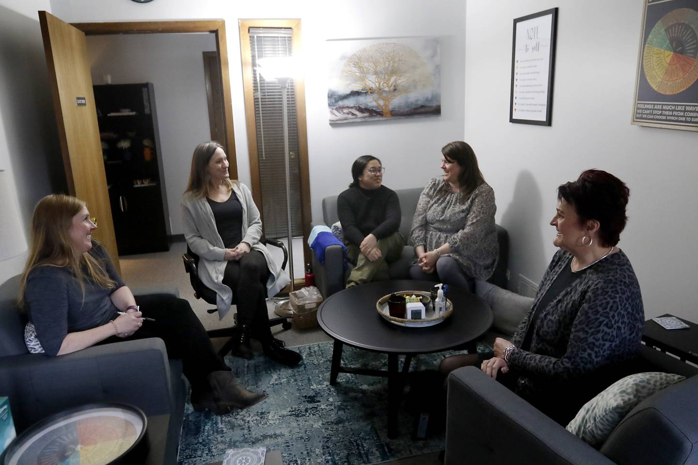 Rebecca Plascencia, second from right, the deputy director of Northwest Center Against Sexual Assault, talks with her co-workers Development Manager Kristen Barry, Executive Director Carrie Estrada, and advocates Jennifer Menchavez, and Pat Bogard at the center’s offices in Arlington Heights on Thursday, March 9, 2023.