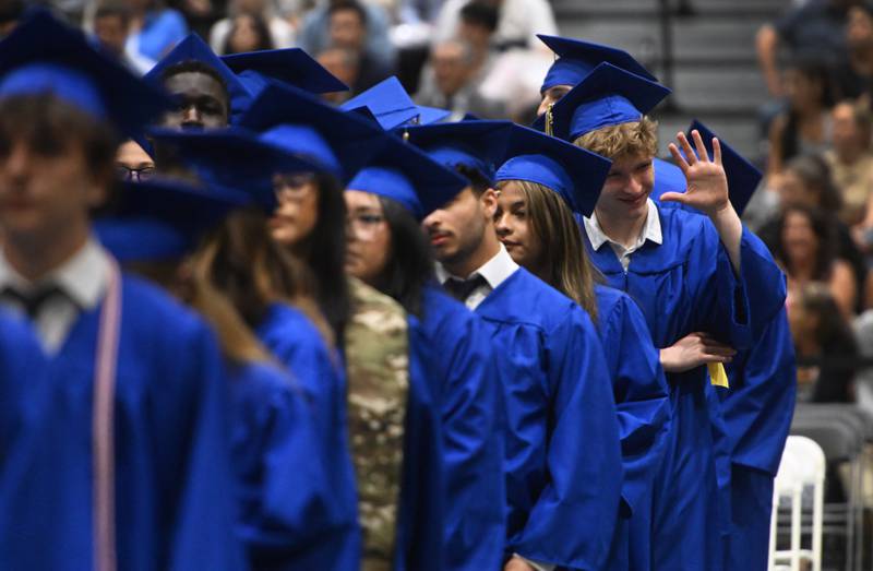 Wheaton North graduate Jacob Randall waves to his parents during the school's commencement  ceremony on Saturday, May 24, 2025 at College of DuPage in Glen Ellyn.