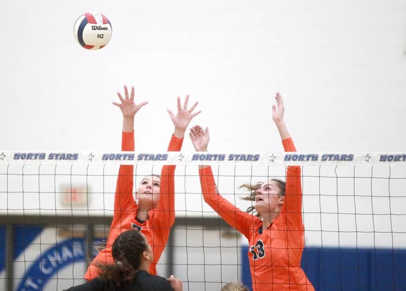 Oswego’s Hannah Herrick (7) and Sidney Hamaker (13) go up for a block during a game Wednesday, Sept. 18, 2024 at St. Charles North.