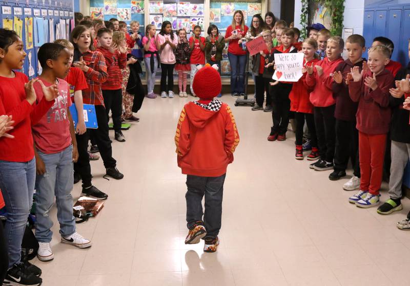 Marshall Morong, (center) 7, a first grader at Hinckley-Big Rock Elementary School, is cheered on as he walks to his classroom Monday, May 5, 2025, after arriving for his first day back at school following months waiting for, and eventually receiving, heart transplant surgery at Lurie Children’s Hospital of Chicago. Morong arrived in style in a Tesla Cybertruck donated for use by Telsa of Naperville, along with an escort by Hinckley and Big Rock first responders.