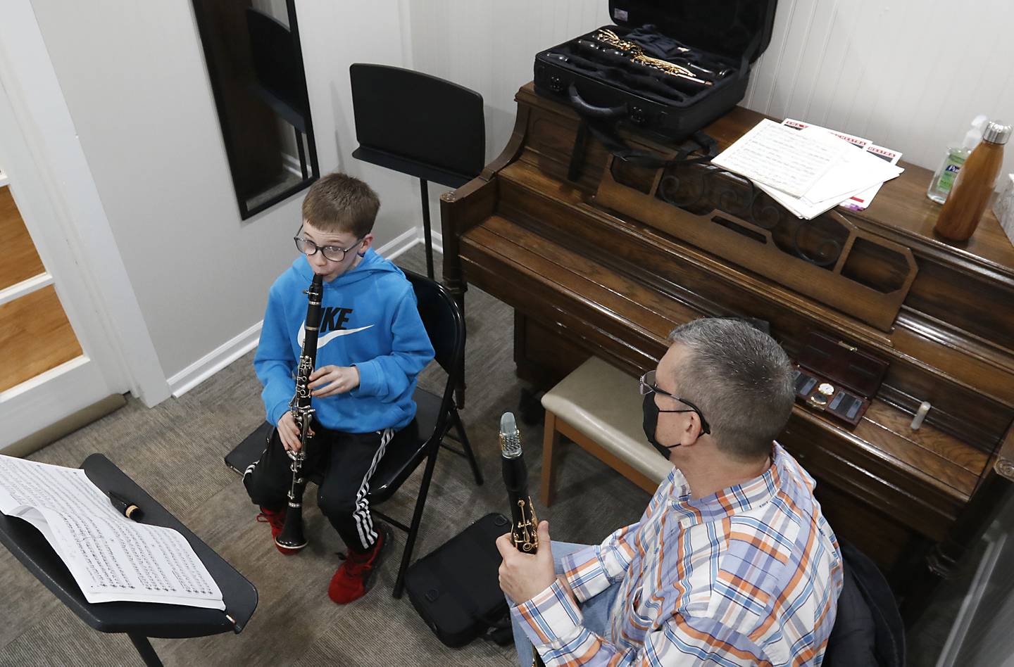 Music teacher Keith Hulen watches as Ethan White, 12, of Crystal Lake, plays the clarinet during a lesson Tuesday, Feb. 22, 2022, at Encore Music Academy, 87 N. Williams St., in Crystal Lake. The academy moved into its new location over Thanksgiving week last year. The larger location allows for the expansion of its private student instruction and also has a large space suitable for performing.