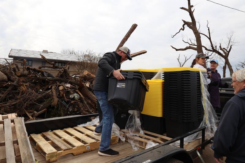 Kankakee Mayor Chris Curtis helps hand out plastic totes to residents in the Oakwoods subdivision in Aroma Township on March 14, 2026, following the March 10 tornado in Kankakee County. The group, including Aroma Park Mayor Brian Stump, state Rep. Jackie Haas, State Sen. Patrick Joyce and his wife Rita, Kankakeean Elisabeth Dunbar, and Curtis' wife, Lori, delivered the donated bins to affected areas in the county.