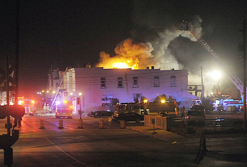 Smoke and flames emerge from an apartment outside Skoogs Pub & Grill on Sunday, May 10, 2015 downtown Utica.