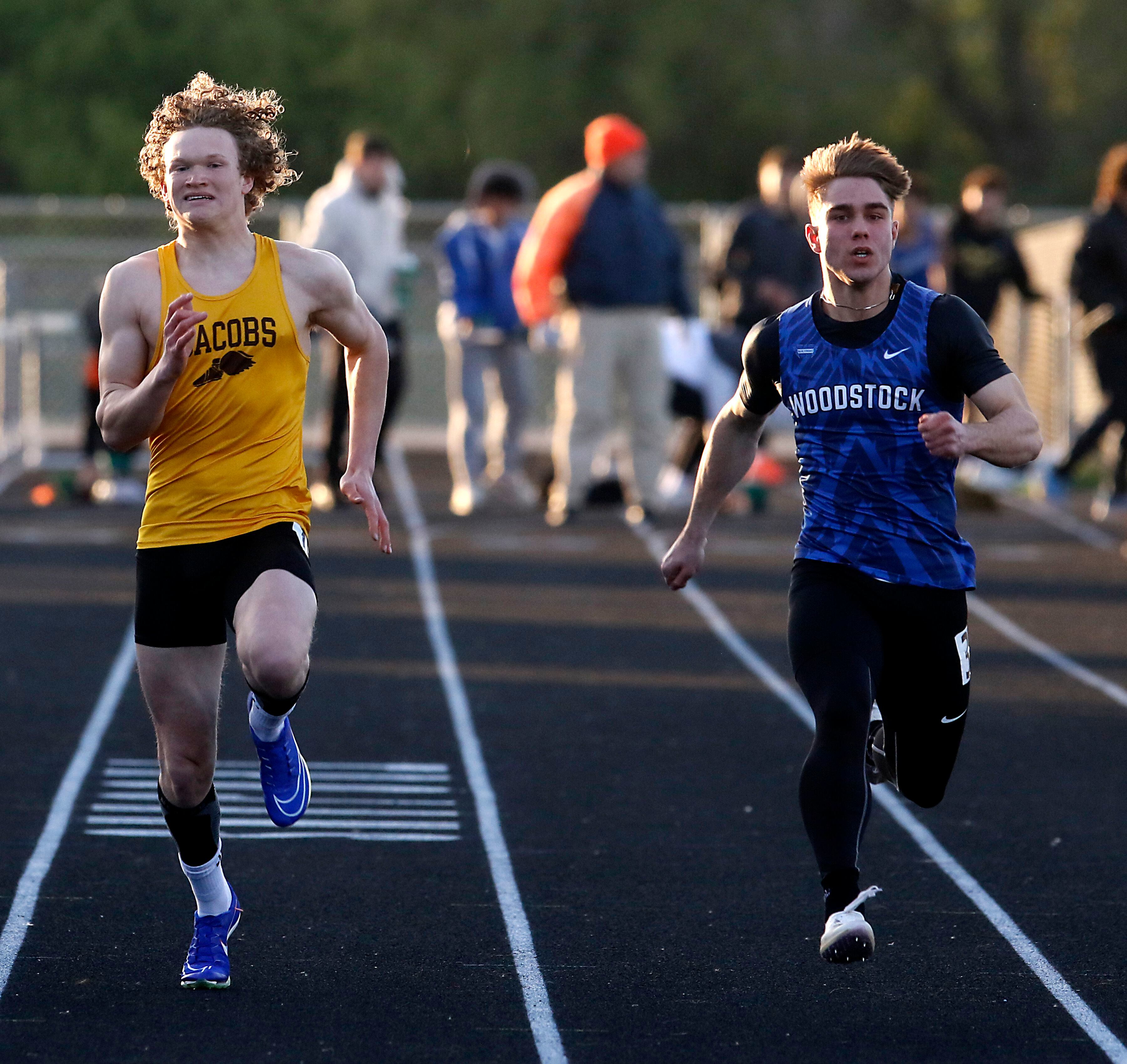 Jacobs’ Jackson Cook and Woodstock’s Nolan Van Hoorn race to the finish line in the 100 meter dash on Friday, April 19, 2024, during the McHenry County Track and Field Meet at Cary-Grove High School.