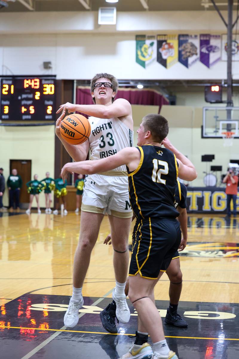 Herscher's Gavin Hull knocks the ball away from Bishop McNamara's Callaghan O'Connor on a shot during Bishop McNamara's 71-42 victory in the IHSA Class 2A Herscher Regional semifinal on Wednesday, Feb. 25, 2026.