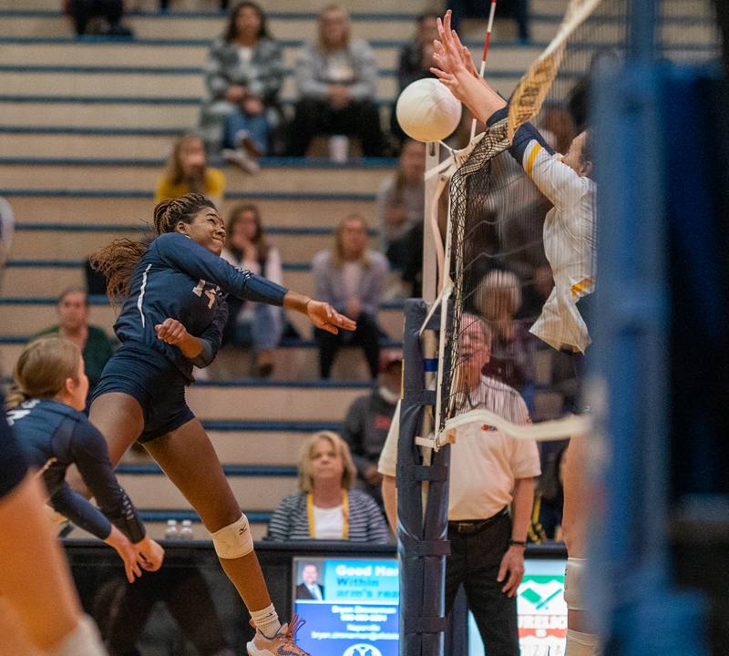 Oswego East's Cailyn Smiley (14) goes up for a kill against Neuqua Valley during the Neuqua Valley 4A regional final volleyball match at Neuqua Valley High School in Naperville on Thursday, Oct 27, 2022.