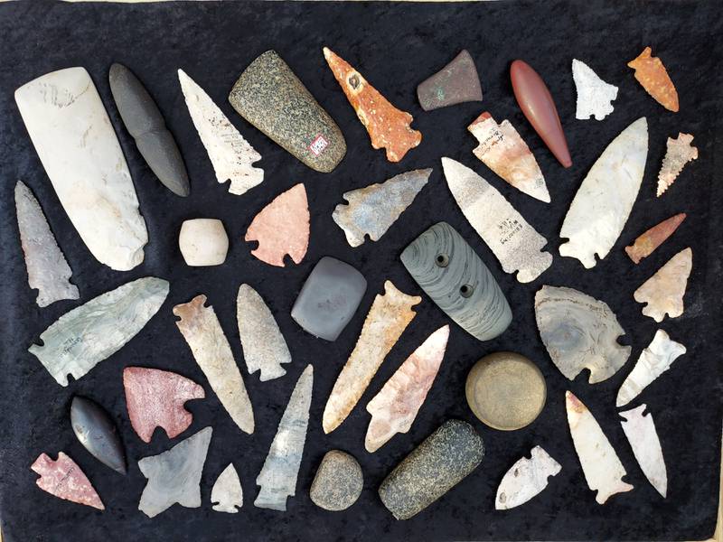 Tristen Arnold, president of the Illinois State Archaeological Society, displays his prehistoric Native American artifacts, such as flint projectile points, stone tools, and ornamental pieces.