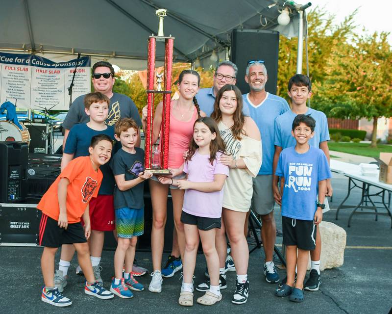 Members of the Hall Hog BBQ are all smiles as they receive the grand champion award during the Cue for a Cause event on Sunday Sep. 1, 2024, in downtown Elmhurst. They also received awards for their sauce and best in ribs.