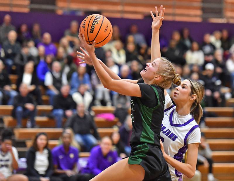 Glenbard West’s Katie Meehan goes for a layup as Downers Grove North’s Eva Yerkovich (right) defends during a game on January 17, 2026 at Downers Grove North High School in Downers Grove .