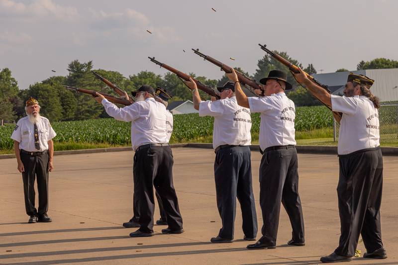 Shot casings fill the air as the Peru Veterans Memorial Group performs a twenty-on gun salute followed by the playing of TAPS during the annual flag retirement ceremony at Veteran's memorial Park on June 14, 2025 in Peru.