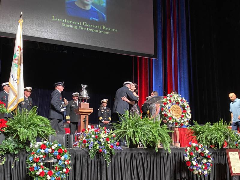 Brittney Ramos, widow of fallen Sterling firefighter Lt. Garrett Ramos, accepts the Line of Duty Death Gold Badge from State Fire Marshal Matt Perez at the 29th annual Fallen Firefighter Memorial and Medal of Honor Ceremony Tuesday, May 10, 2022, in Springfield. Ramos, 38, died Dec. 4 fighting a house fire in Rock Falls. He was the first firefighter in the Sterling Fire Department’s 150-year history to die in the line of duty.