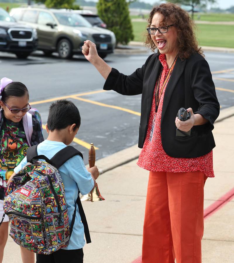 DeKalb School District 428 Superintendent Minerva Garcia-Sanchez lets Gwendolyn Brooks Elementary School students ring the bell as they arrive at the school Thursday, Aug. 17, 2023, on the first day for most students in DeKalb.