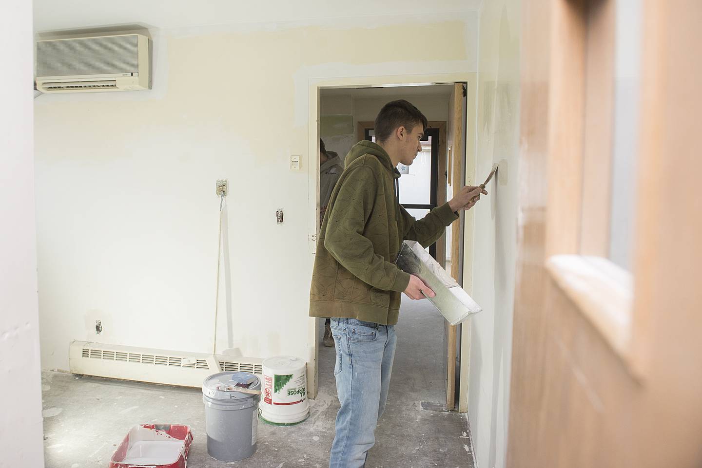 Donald Schofield of Rock Falls High School works on the drywall of a break room at the Regional Office of Education with other members of his building trades class.