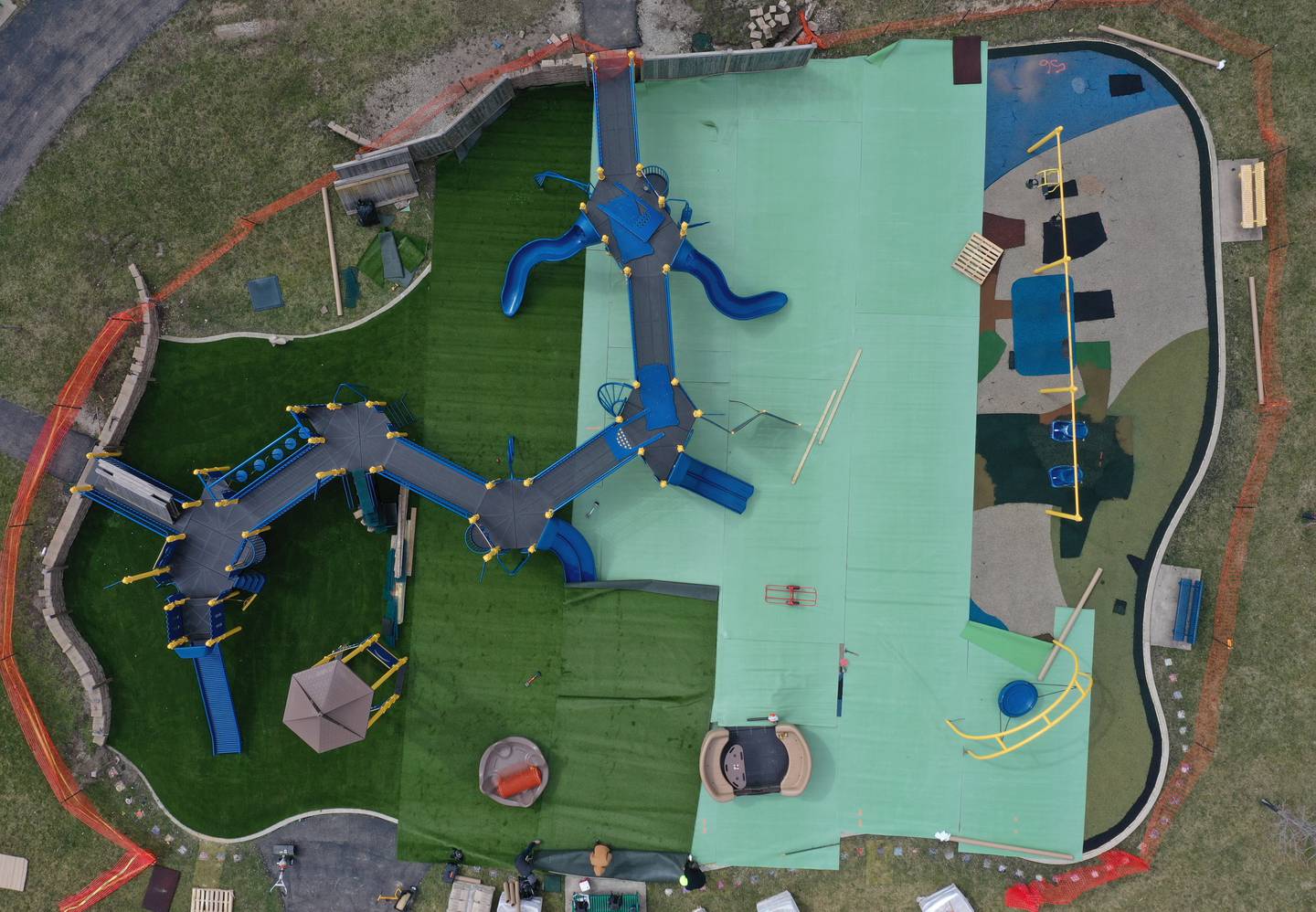 A crew from Teim Reil Inc. install new artificial turf at the playground at Rotary Park on Monday, March 18, 2024 in La Salle. The playground will be re-surfaced and completed on March 25. The playground will be closed until work is finished.
