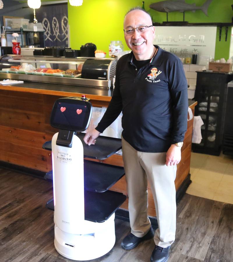 Mushroom, the sushi serving robot at Fushi Yami hibachi and sushi restaurant, with the manager Brian Chen Friday, Jan. 19, 2024, at the eatery in DeKalb.