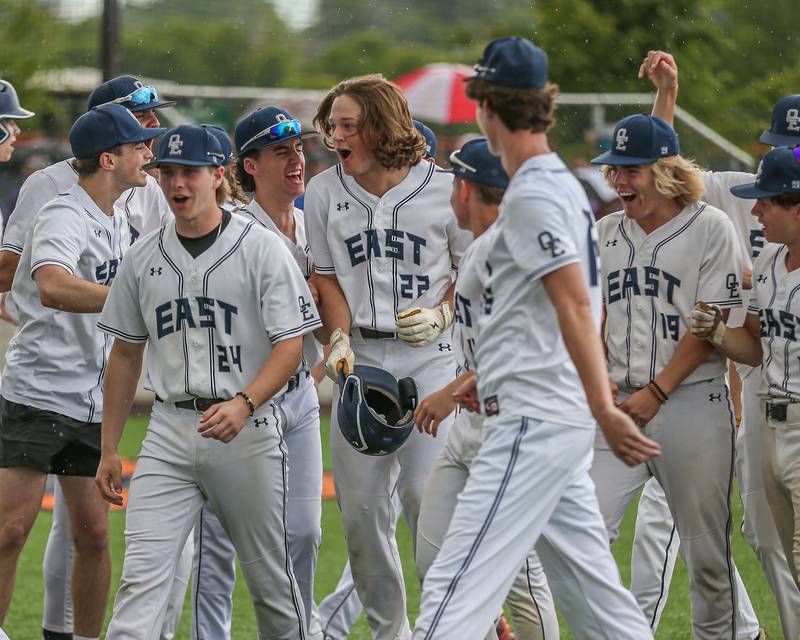 Oswego East's Jackson Petsche (22) is welcomed at the plate by teammates after hitting a homerun during Class 4A Romeoville Sectional semifinal between Oswego East at Downers Grove North.  May 31, 2023.