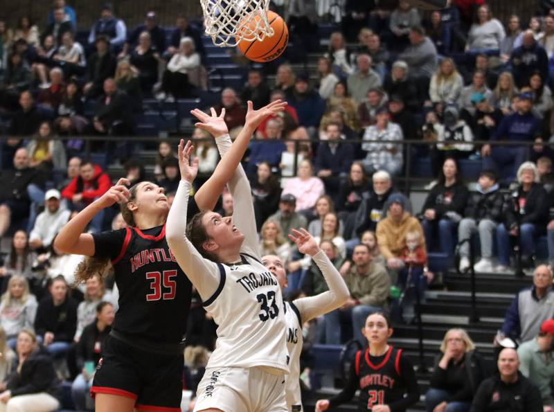 A crowded gym watches Huntley’s Paula Strzelecki, left, and Elizabeth Mjaanes vie for a rebound in varsity girls basketball on Friday, Jan. 24, 2025, at Cary-Grove High School in Cary.