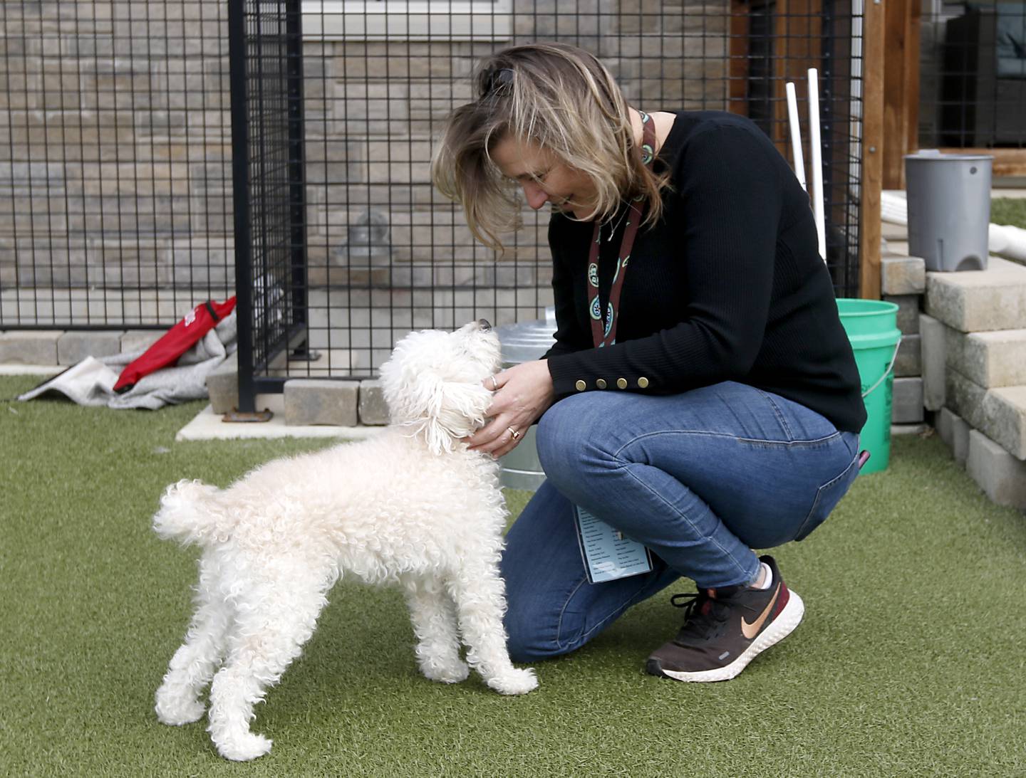 Jennifer Waldack, a fourth grade teacher at Mary Endres Elementary School, interacts with a dog at Young At Heart on Tuesday, March 21, 2023, during a field trip to the senior animal rescue facility. Waldack helps run her school's Difference Makers program.