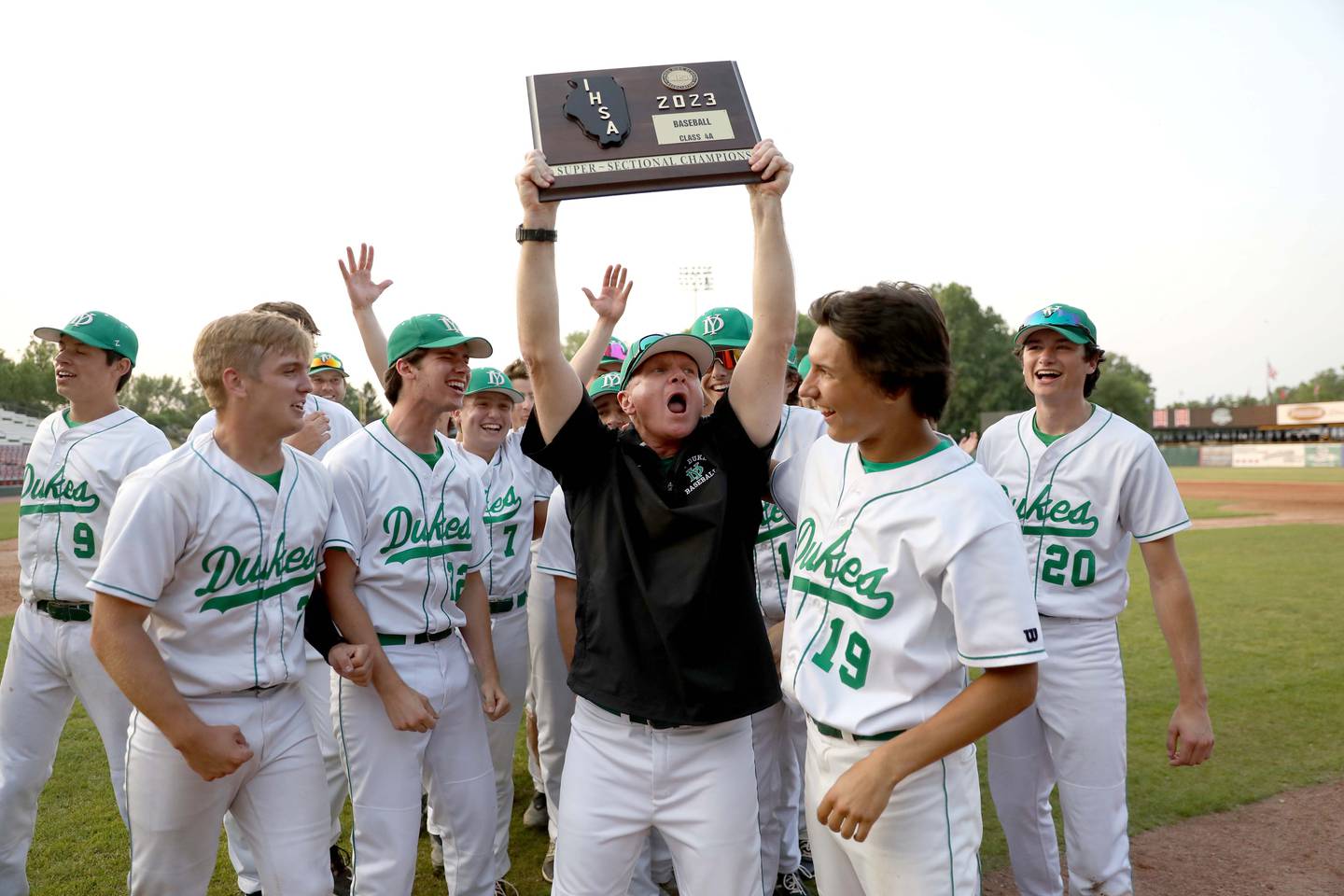 York Head Coach Dave Kalal hoists the trophy following their Class 4A Kane County Supersectional win against Hononegah at Northwestern Medicine Field in Geneva on Monday, June 5, 2023.