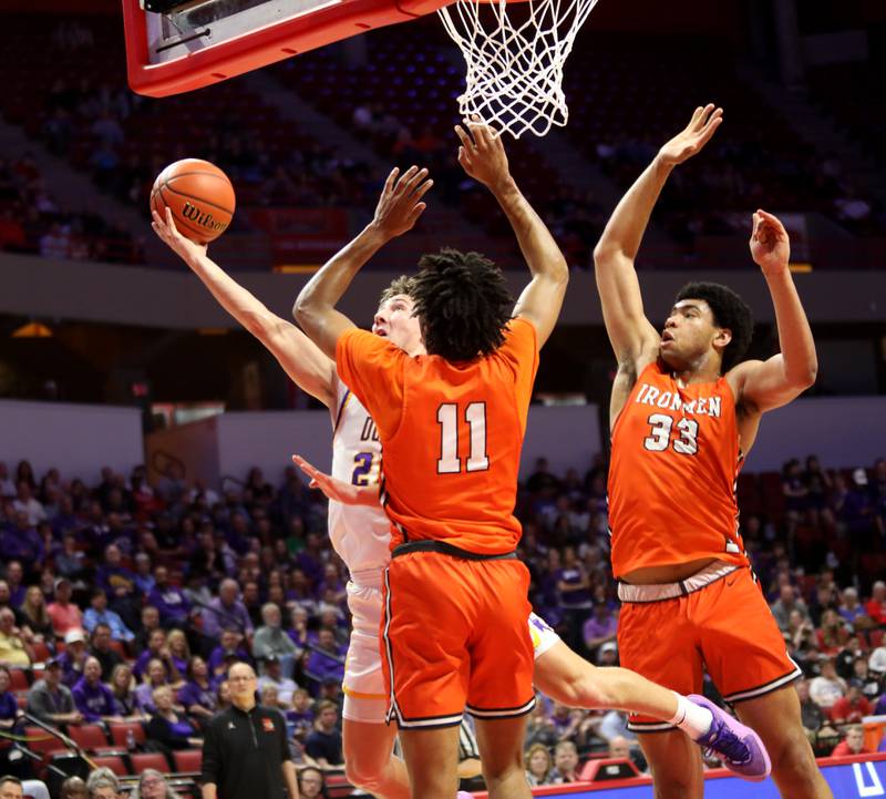 Downers Grove North’s Jack Stanton attempts a shot past Normal Community defenders Braylon Roman (left) and Jaheem Webber (right) during the Class 4A Normal Supersectional game on Monday, March 4, 2024.