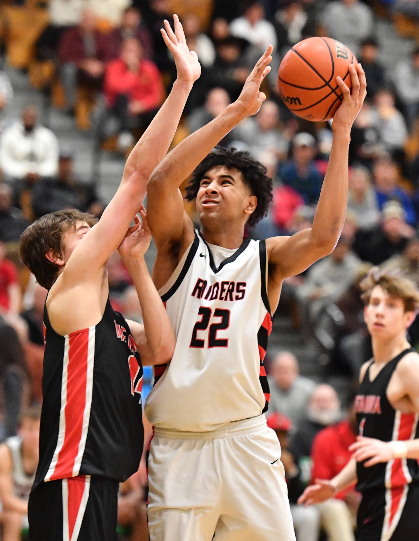 Bolingbrook's JT Pettigrew (22) takes the ball to the basket during the Jack Tosh Classic championship game against Metamora on Dec. 30, 2023 at York High School in Elmhurst.