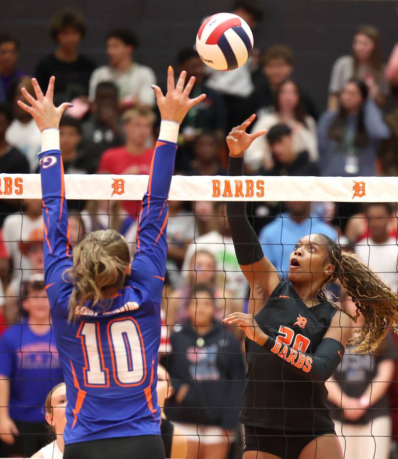 DeKalb's Zora Watts tries to tip the ball by Genoa-Kingston's Bria Botterman during their match Wednesday, Sept. 10, 2025, at DeKalb High School.