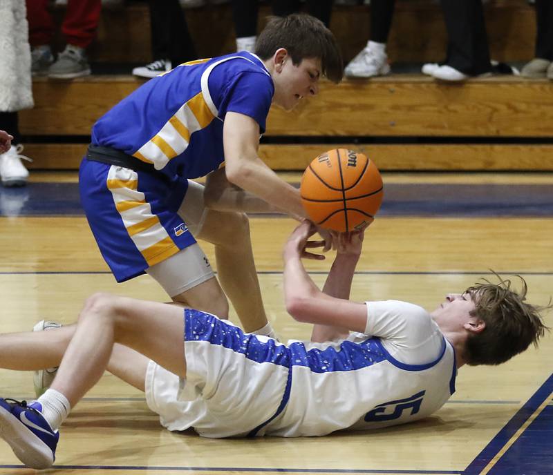 Johnsburg's Trey Toussaint battles with Woodstock's Liam Laidig for a loose ball during a Kishwaukee River Conference basketball game on Friday,  Feb. 14, 2025, at Woodstock High School.