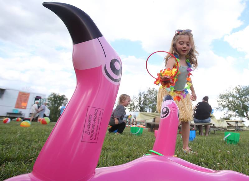 Willow Thomas of Marseilles, tosses rings on inflatable flamingos during Marseilles Fun Days on Tuesday, June 24, 2025 at the Marseilles Community Boat Launch. The festival featured Jimmy Buffett themed music, kids games and a ducky derby. Marseilles Fun Days runs through Sunday with different themed-nights.