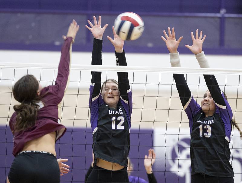 Dixon’s Isabelle Quackboerner (left) and Solis Thompson go up for a block against Morris Thursday, Oct. 31, 2024 in the class 3A regional championship at Dixon High School.