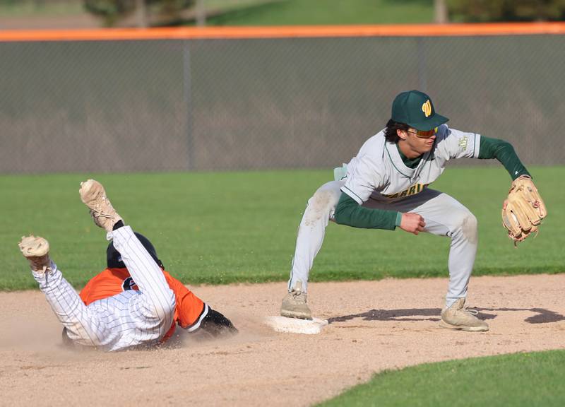 DeKalb's Luke Duffy gets back to second base safely just as Waubonsie Valley's Scott Gillen catches the throw Monday, April 20, 2026, during their game at DeKalb High School.