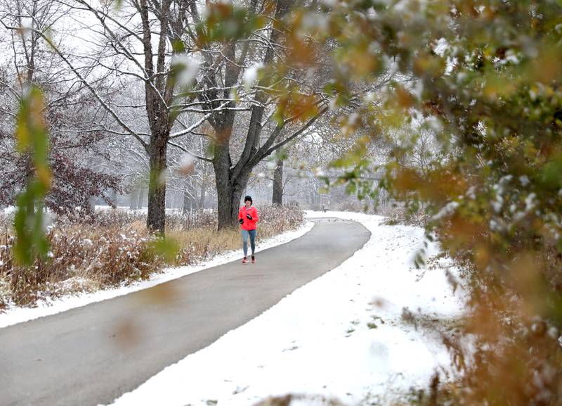 Nicole Tucker of Geneva runs as the first snow of the season falls at Fabyan West in Geneva on Tuesday, Nov. 15, 2022.