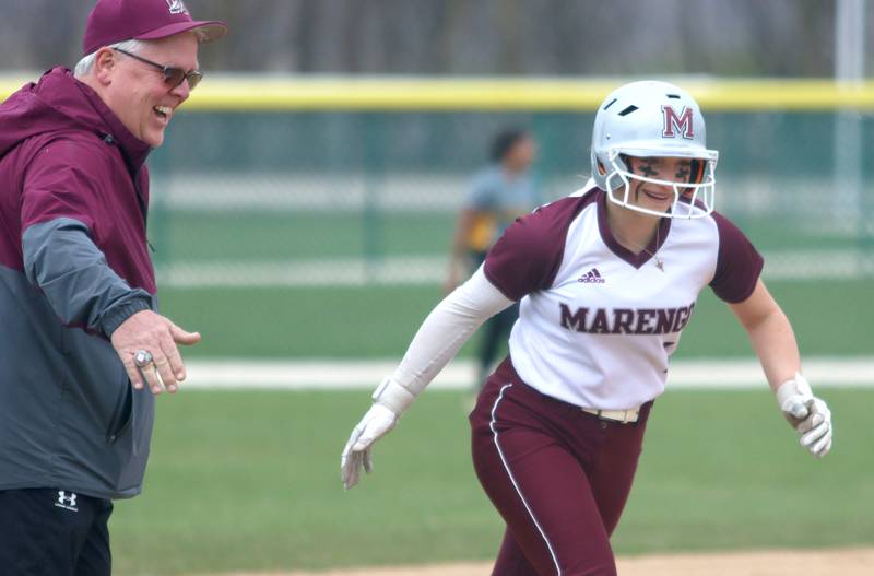Marengo’s Gabby Christopher is greeted by coach Rob Jasinski on a home run against Harvard in varsity softball at Marengo Thursday.