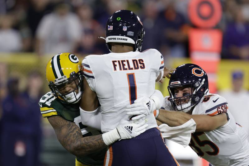 Chicago Bears quarterback Justin Fields is hit by Green Bay Packers linebacker Preston Smith after throwing a pass during the first half, Sunday, Sept. 18, 2022, in Green Bay, Wis.