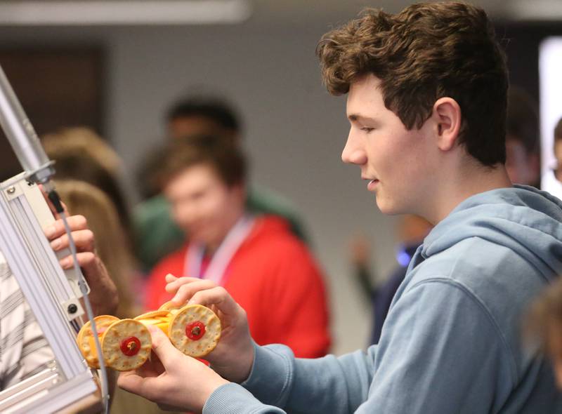 Ayden Sexton a student at Ottawa Township High School, inserts his edible car on the ramp during the 29th annual Edible Car Contest on Wednesday, Feb. 26, 2025 in the cafeteria at Illinois Valley Community College.