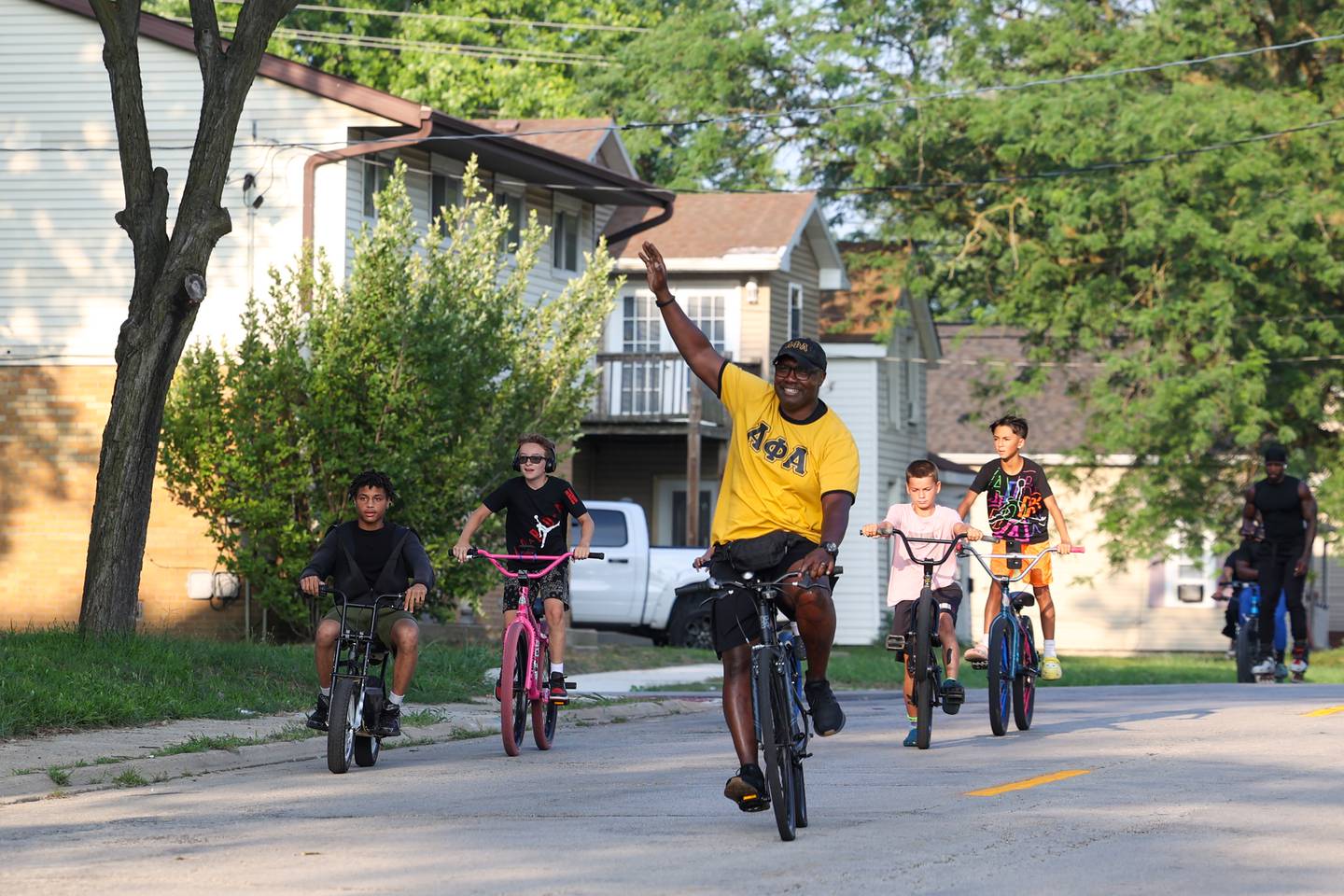 Kankakee Police Deputy Chief Donell Austin, center, waves to residents as he helps lead the group along East Chestnut Street in Kankakee during the annual Bike Against Violence ride on Tuesday, July 22, 2025.