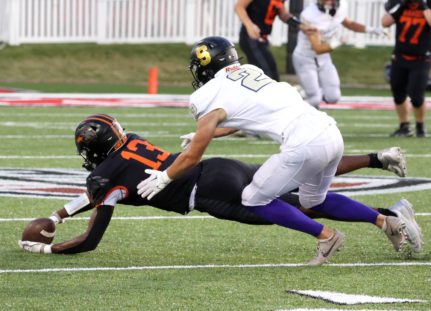 DeKalb's Davon Grant comes up with a diving catch in front of Sycamore's Thatcher Friedrichs Friday, Aug. 30, 2024, during the FNBO Challenge at Huskie Stadium at Northern Illinois University.