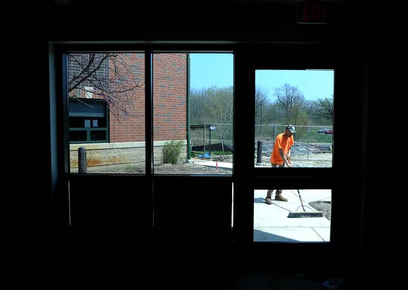 Erick Baeza of MGC General Contractors sweeps a new sidewalk Tuesday, May 10, 2022, as he works on a new outdoor patio area at Valley Hi Nursing Home, 2406 Hartland Road in Woodstock. Valley Hi is working on a series of renovations to its facility, while also planning for a memory care wing to be created in the coming years.