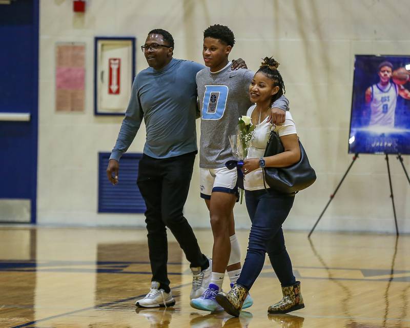 Downers Grove South's Jalen House (0) comes out with his parents during senior night activities before their game versus Leyden.  Feb 8, 2024