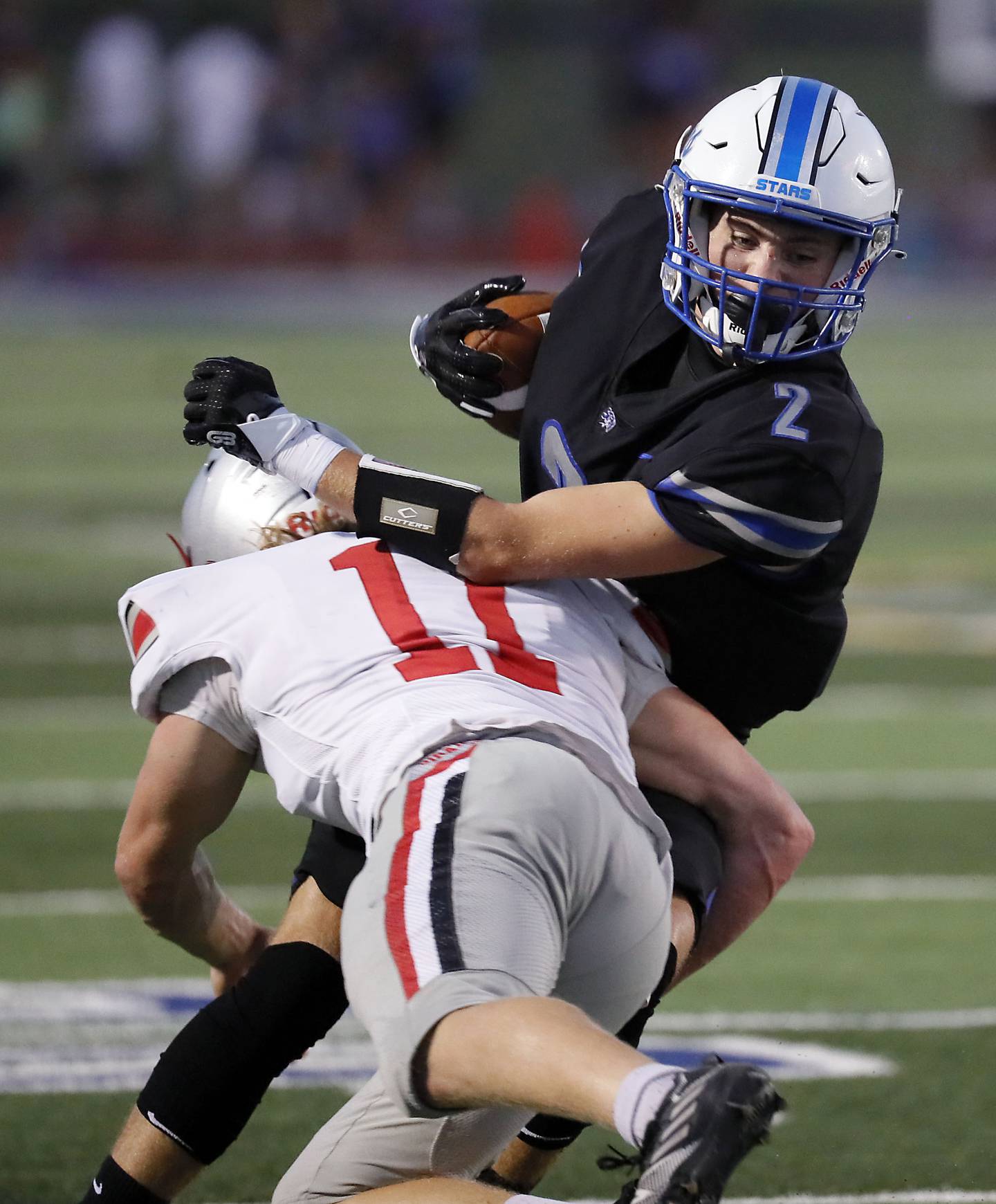 St. Charles North's Aedan Hayes (2) tries to slide past Palatine's Trey Widlowski (11)  Friday August 25, 2023 in St. Charles.