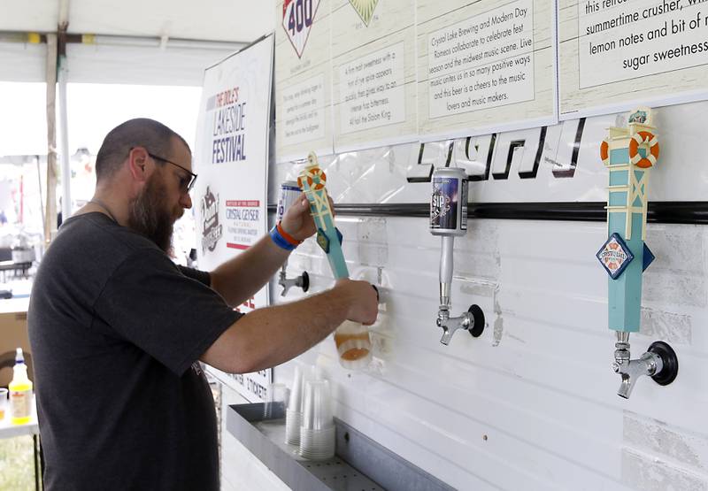 Kevin Fraser pours a Crystal Lake Brewing Company beer during Lakeside Festival Friday, June 30, 2023, at the Dole and Lakeside Arts Park in Crystal Lake.