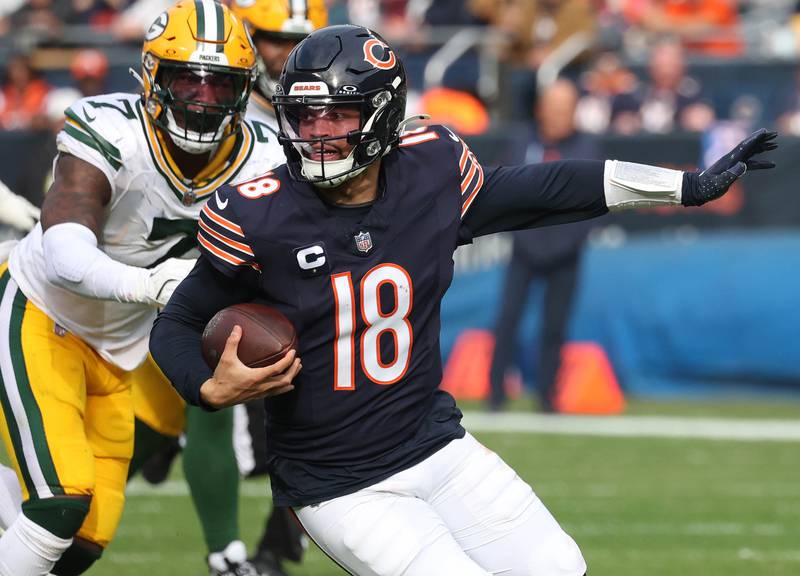 Chicago Bears quarterback Caleb Williams runs ahead of Green Bay Packers linebacker Quay Walker Sunday, Nov. 17, 2024, during their game at Soldier Field in Chicago.