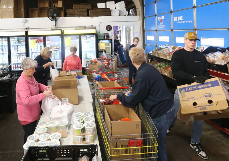 Volunteers fill baskets full of food on Wednesday April 5, 2023 at the Hall Township Food Pantry in Spring Valley.