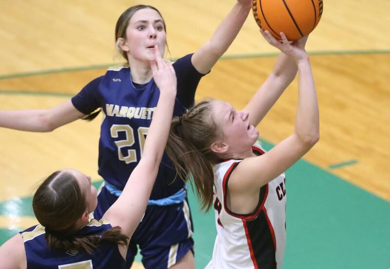 Amboy/Ohio's Bella Yanos splits Marquette defenders Chloe Larson and Kaitlyn Davis to score on a layup during the Class 1A Regional championship on Thursday, Feb. 20, 2025 at St. Bede Academy.