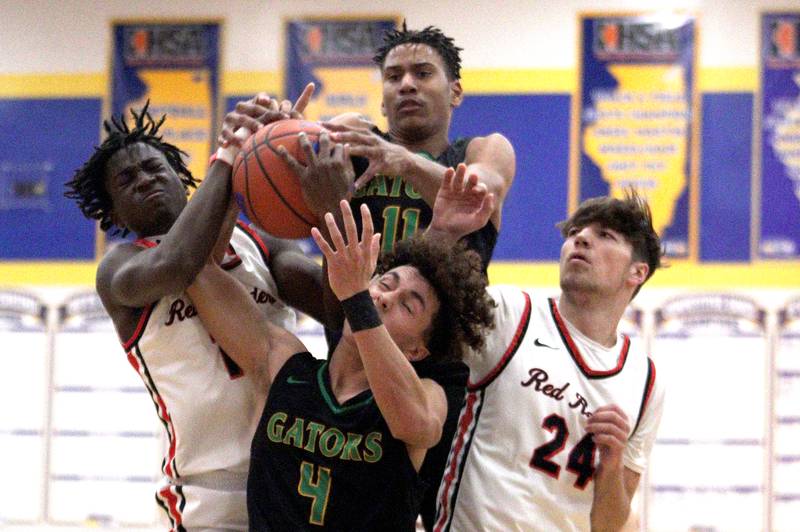 Huntley’s Sheldon Bonsu, left, and Ryan Sweeney, right, battle Crystal Lake South’s Anthony Demirov, center low, and Christian Rohde, center high, in varsity basketball tournament title game action at Johnsburg Friday.