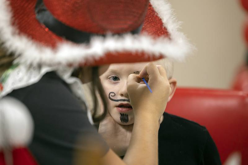 Kalvin Helms, 5, gets a dashing new look from sister Rylie Helms, 13,  Wednesday, Dec. 11, 2024, at the face painting booth at the Whiteside County Senior Center.