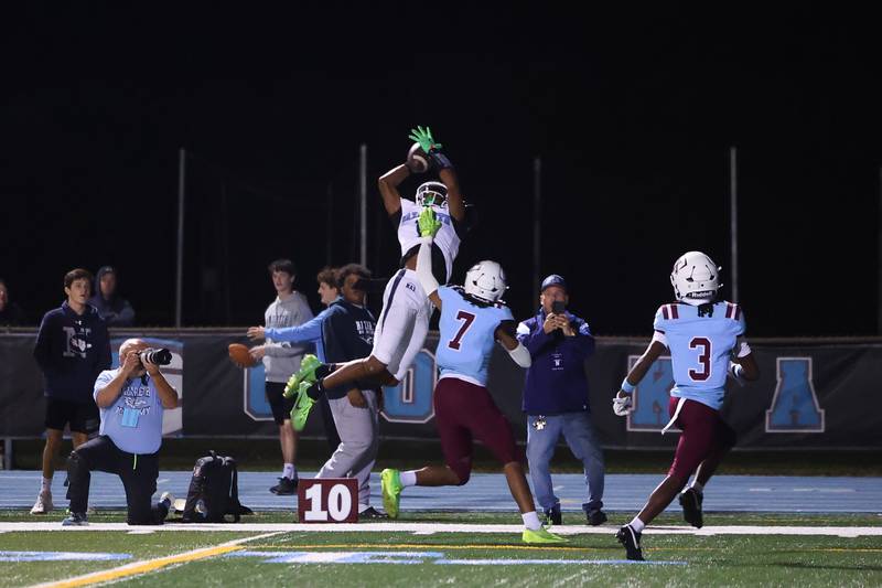 Nazareth's Trenton Walker makes a leaping catch over Kankakee's Dominic White (7) during Kankakee's 33-12 loss to Nazareth on Friday, Aug. 29, 2025.
