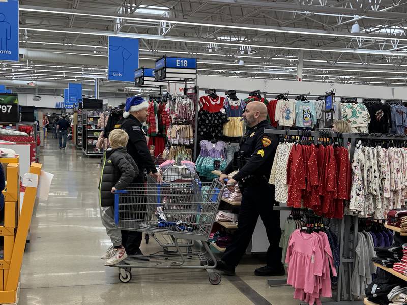 Sgt. Matt Juras with the Minooka Police Department and Jaxten go from aisle to aisle at Shop with a Local hero.