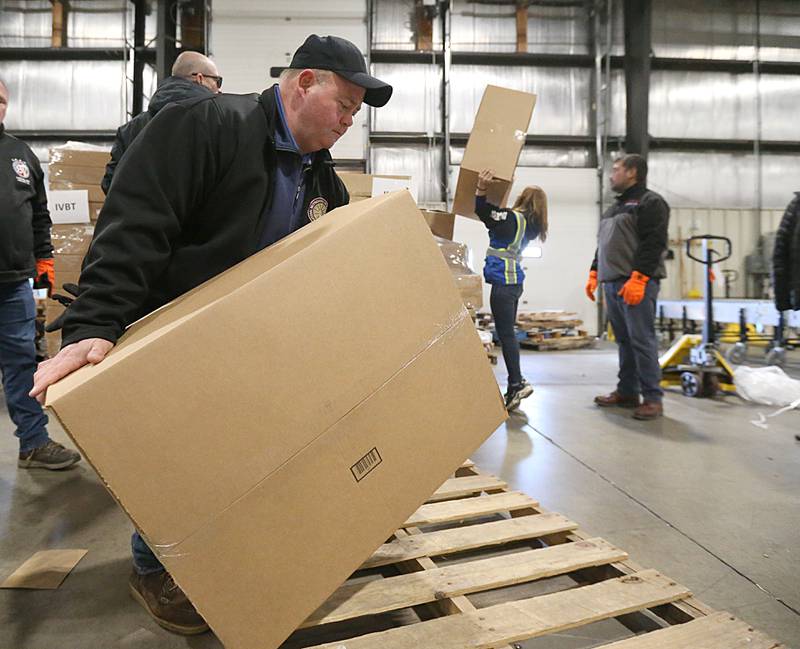 Floyd Jones president of Illinois Valley Building Trades, loads a bicycle off of a pallet and onto a semi on Thursday, Dec. 1, 2022 at DD Warehouse in Peru.